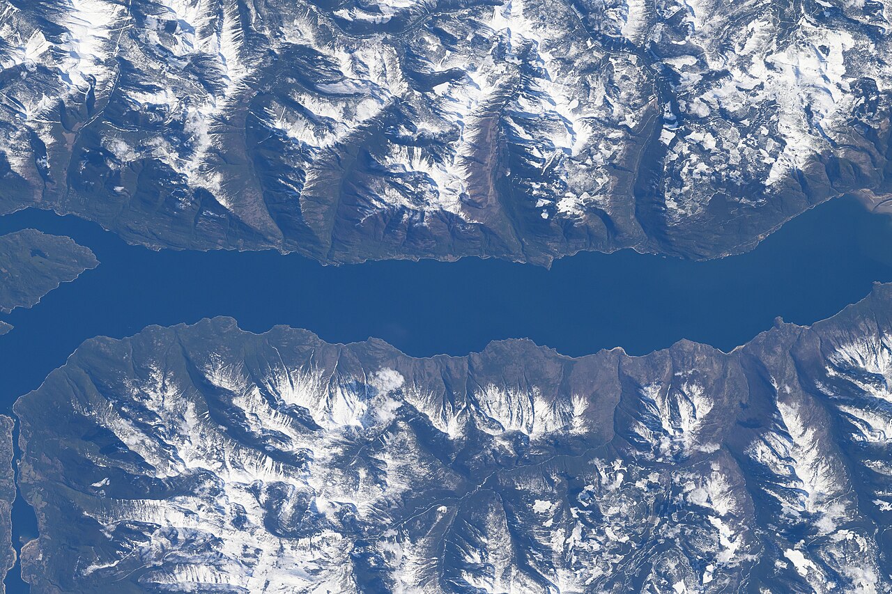Der südliche Teil des Kootenay Lake in den kanadischen Rocky Mountains, westlich angrenzend die Darkwoods und andere Gebiete (hier unten), Aufnahme der ISS vom 13. April 2024 aus 260 Meilen Entfernung, Quelle: NASA iss071e007896 auf Wikipedia, gemeinfrei 