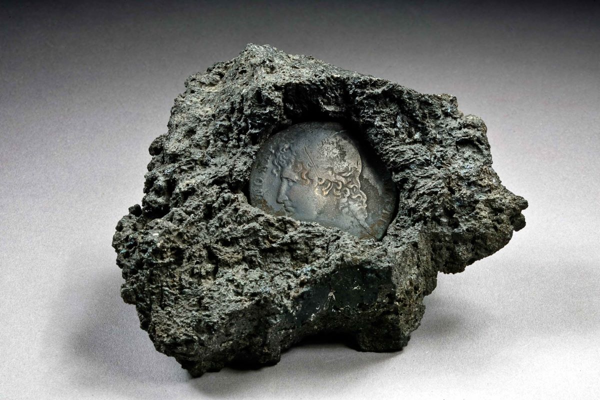  Lava mit eingeschmolzener Münze [Quelle: Naturkundemuseum Karlsruhe, Foto: Volker Griener]