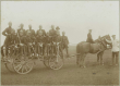 12 Soldaten in Uniform und Pickelhaube, ein Zivilist mit Hut auf Pferdefuhrwerk teils stehend, teils sitzend auf Truppenübungsplatz bei Münsingen, Bild 1