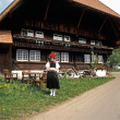 Frau in Gutacher Tracht mit Bollenhut, vor Schwarzwaldhaus, 1991